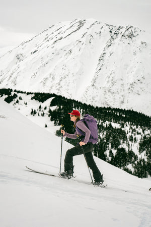 Woman skinning up a snowy slope